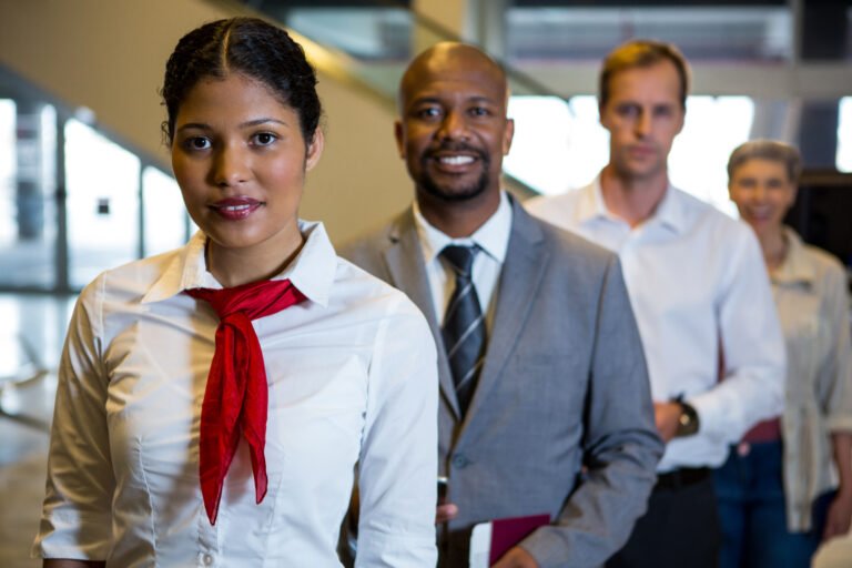 Portrait of female staff and passengers standing in the airport terminal